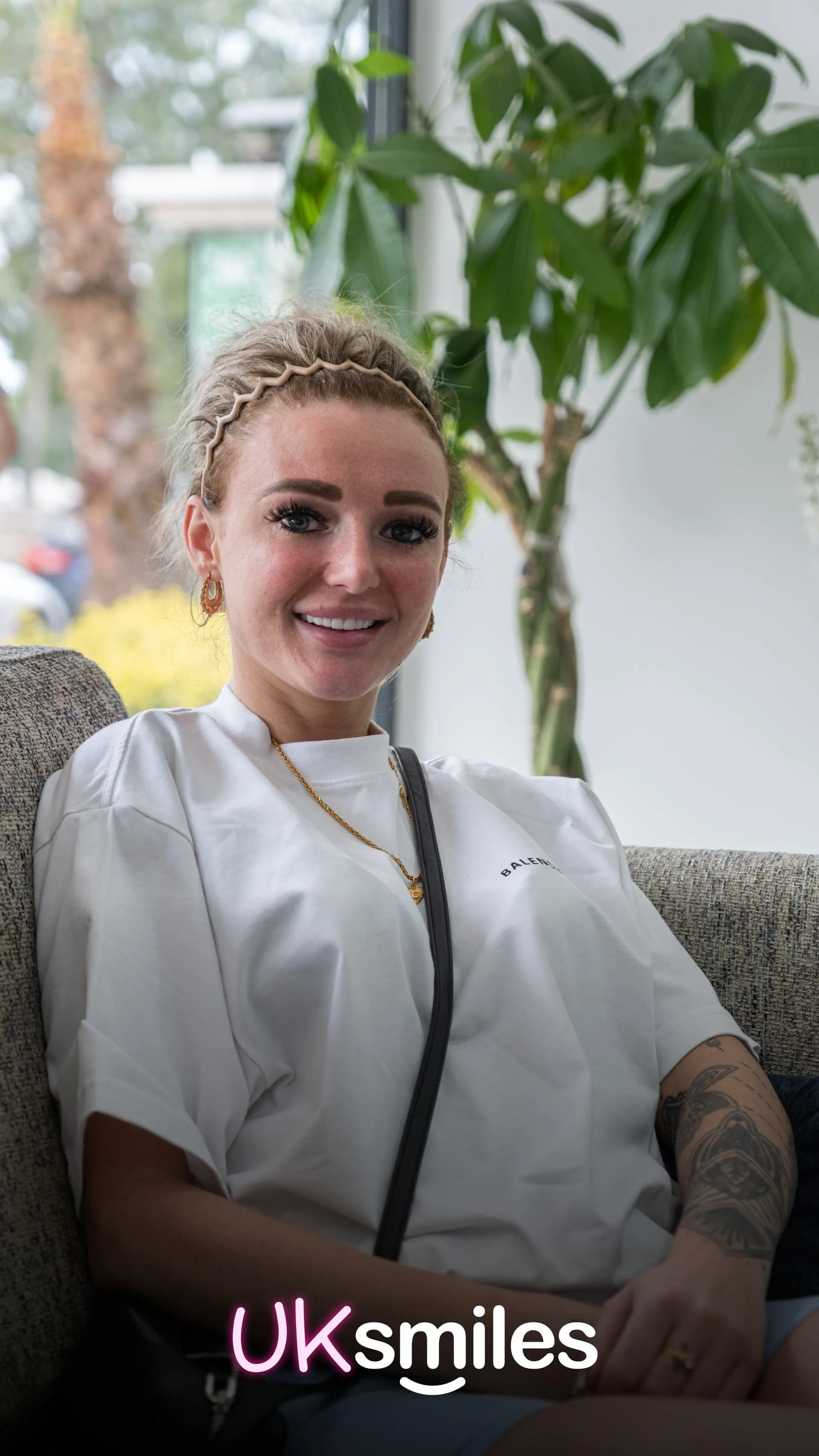 Smiling patient with braided blonde hair in the clinic lounge in Antalya after her treatment
