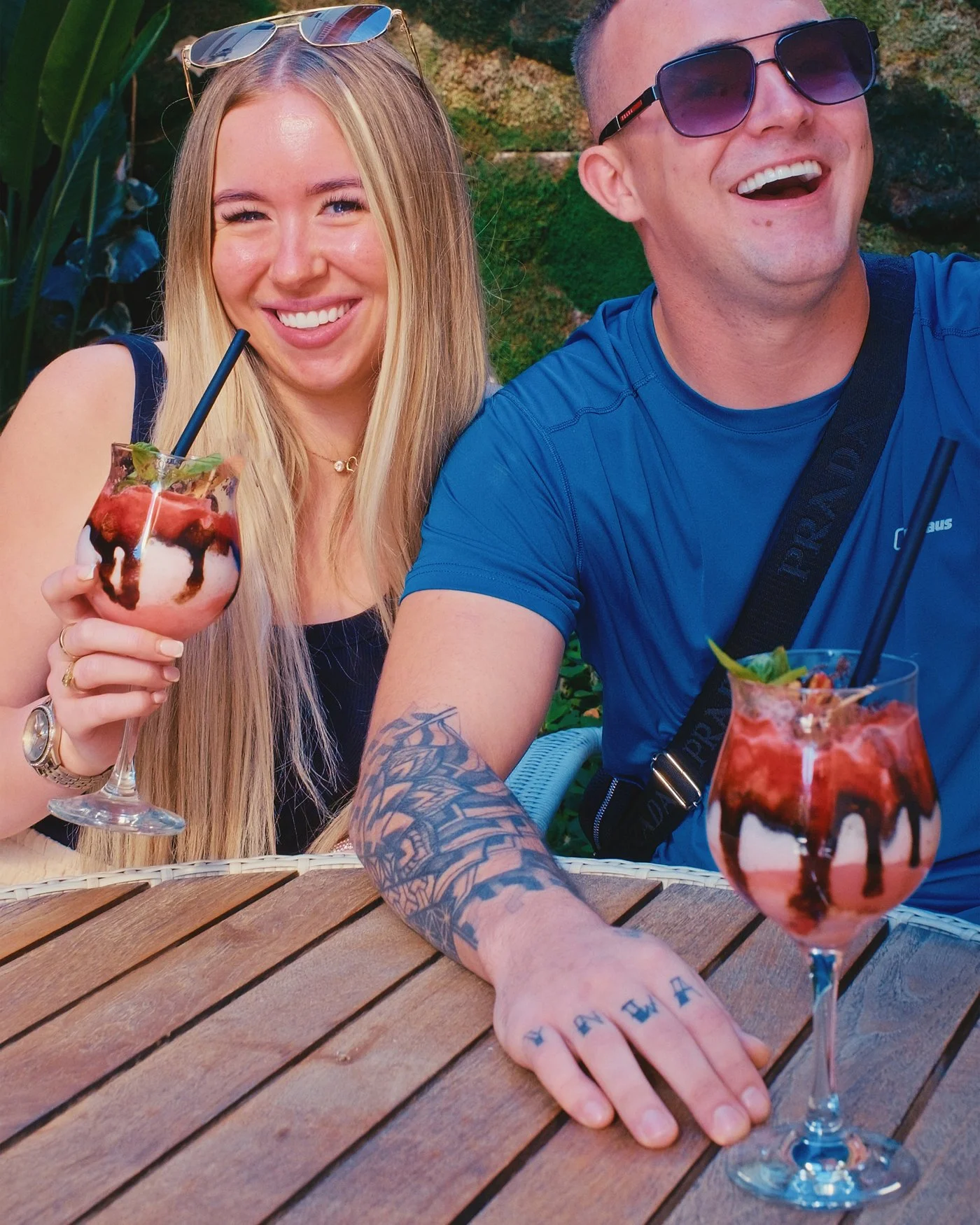 Two UK Smiles patients laughing over drinks in a hotel garden in Antalya after their treatment