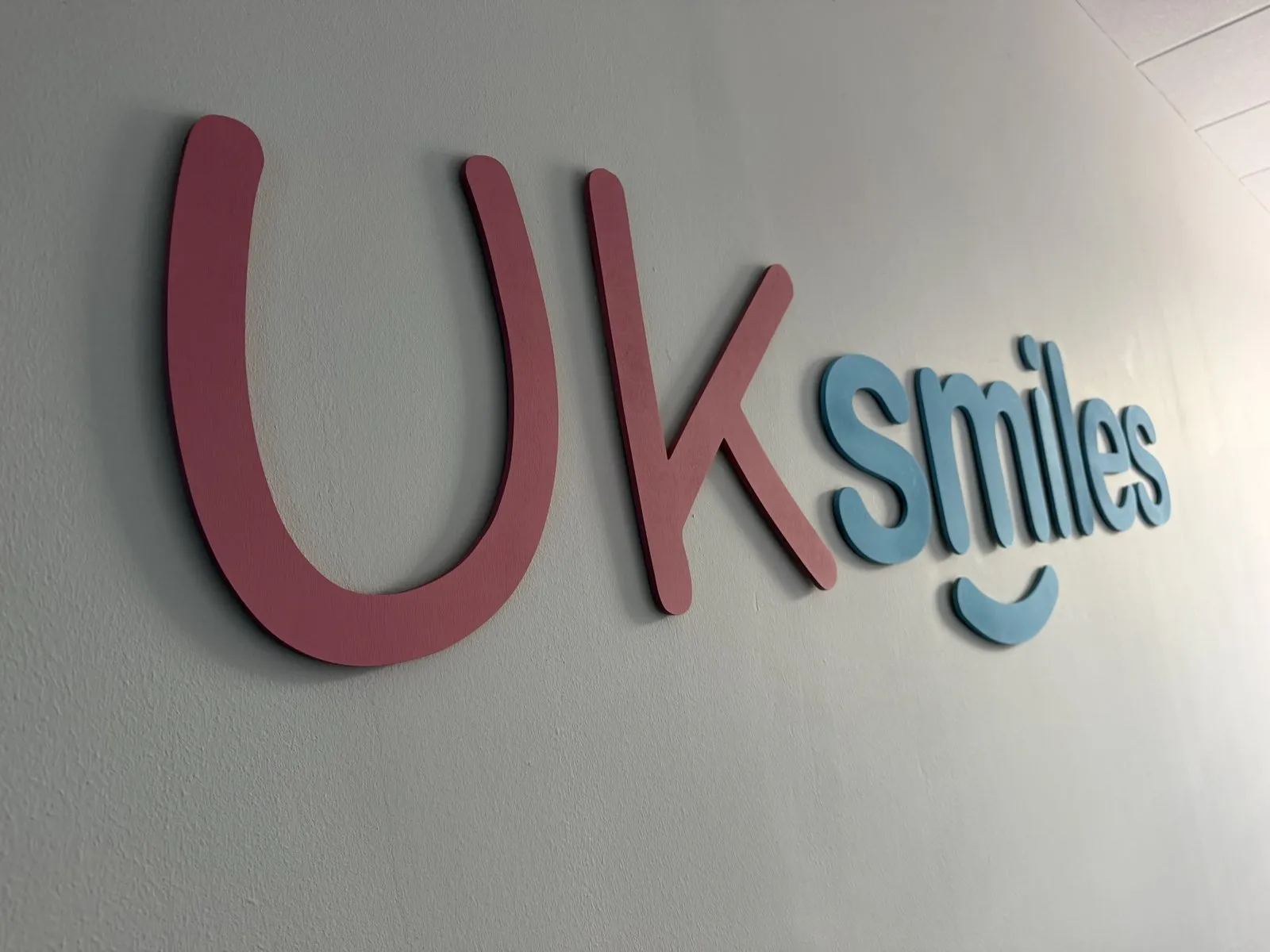 The UK Smiles logo on the wall of the Leeds office at Joseph's Well