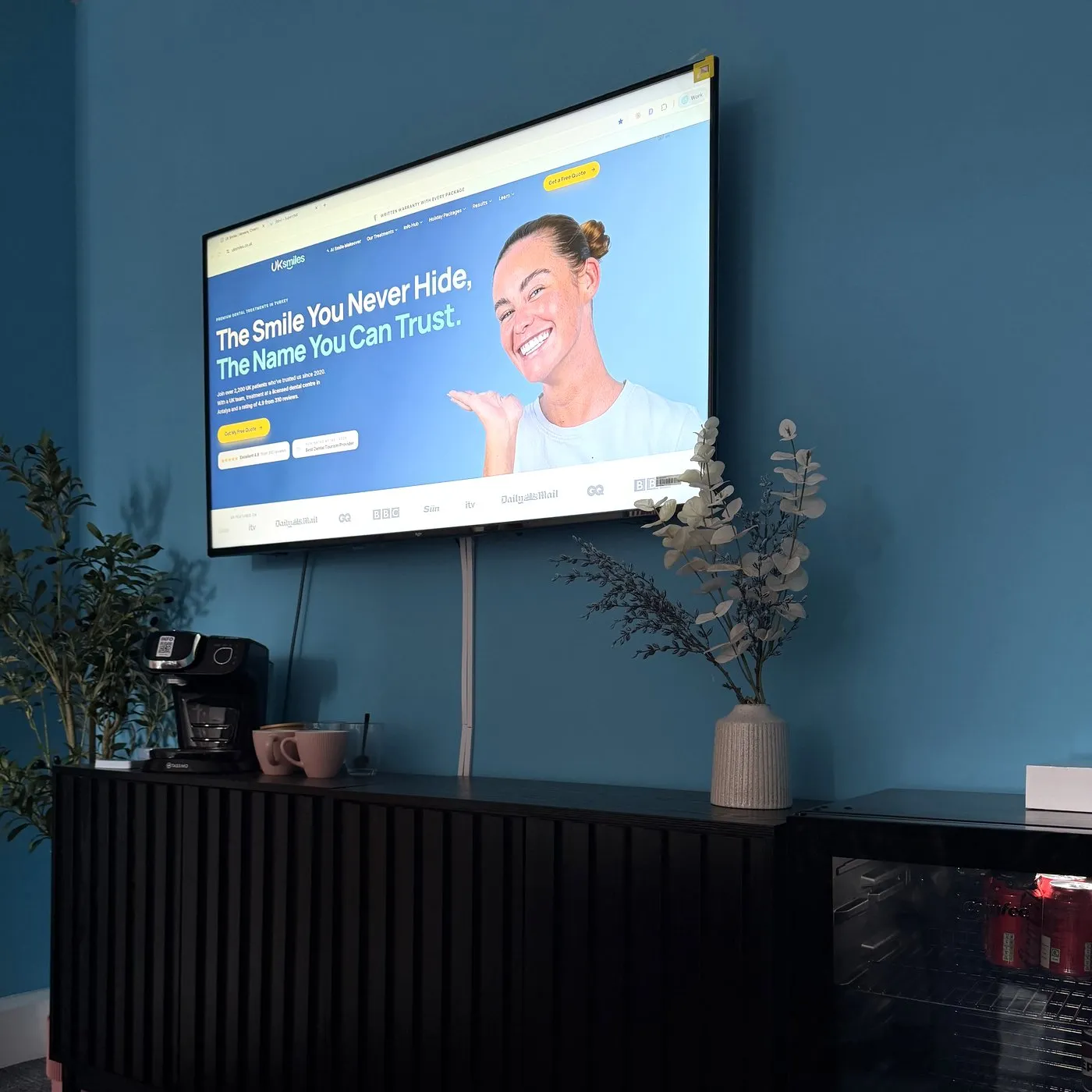 The coffee corner in the UK Smiles Leeds office, with the website on the TV above a sideboard