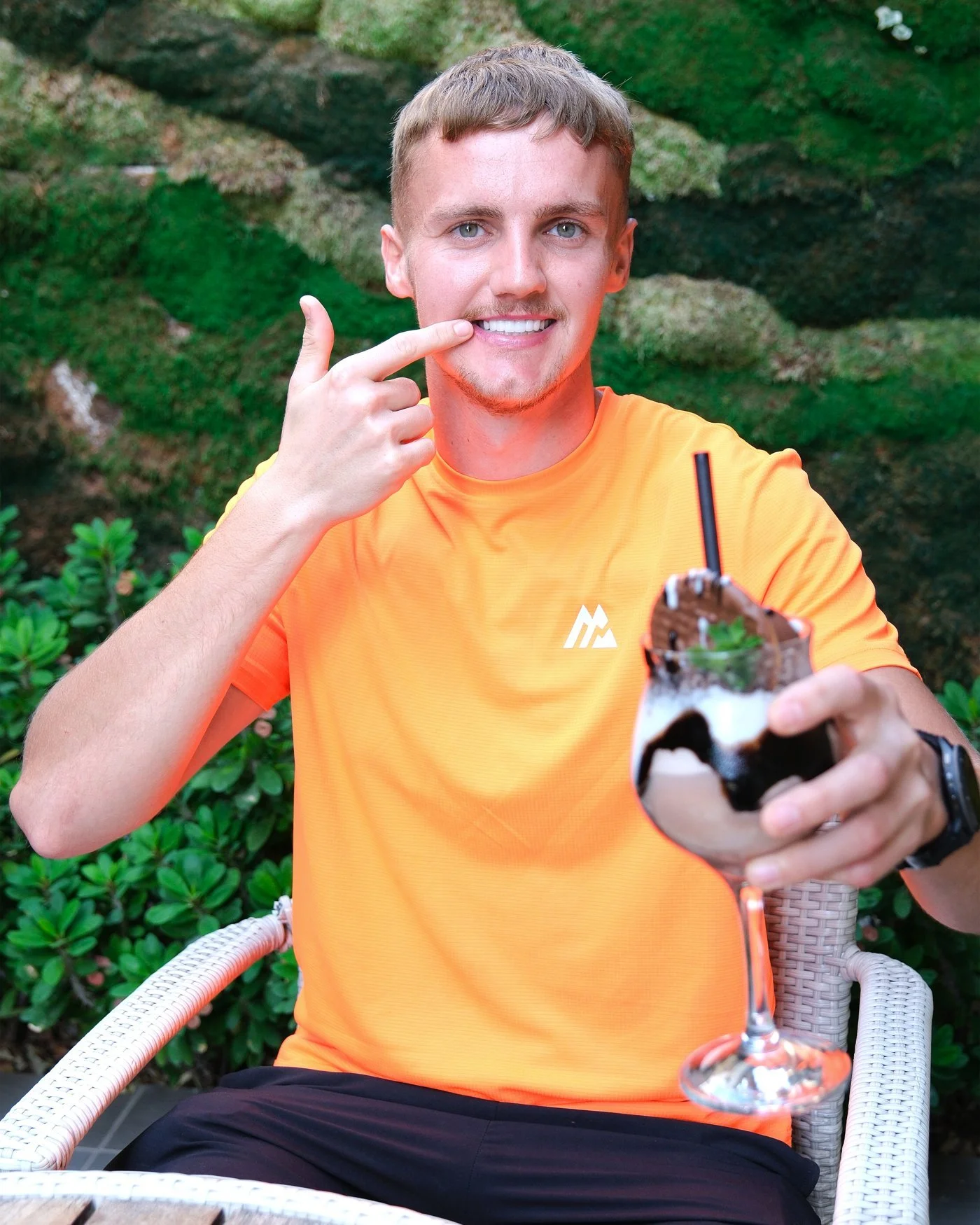 A UK Smiles patient pointing to his new smile in a hotel garden in Antalya
