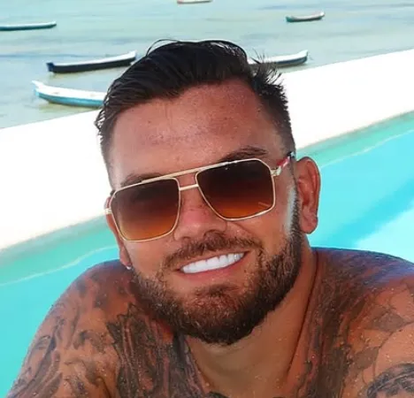 Sam Gowland smiling poolside in sunglasses, showing his bright, even teeth