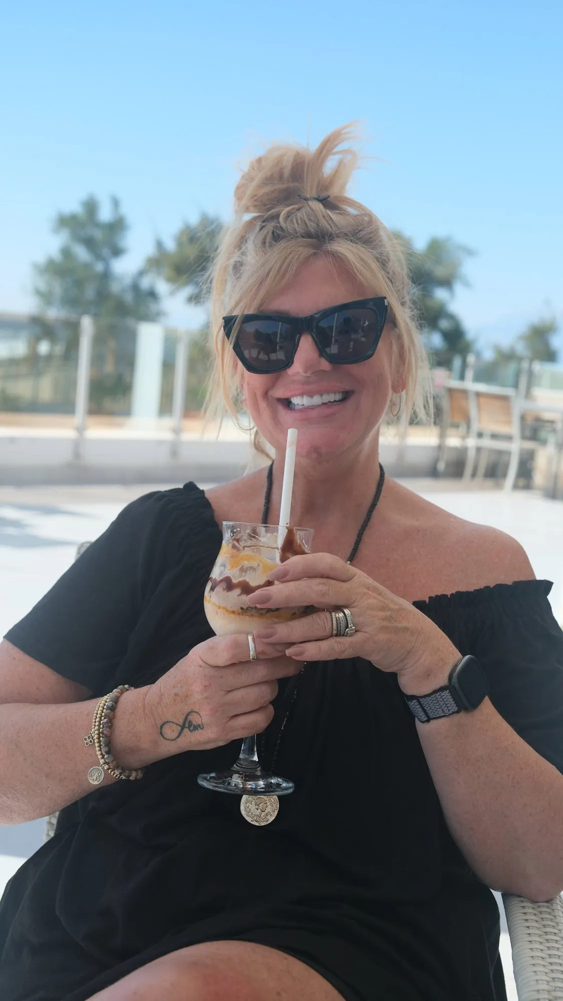 A UK Smiles patient holding a drink on a sunny hotel terrace in Antalya after treatment