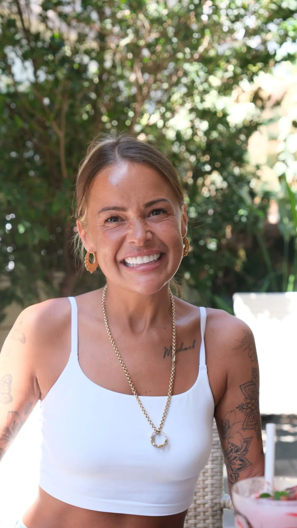 A UK Smiles patient smiling with her new teeth in a hotel garden in Antalya